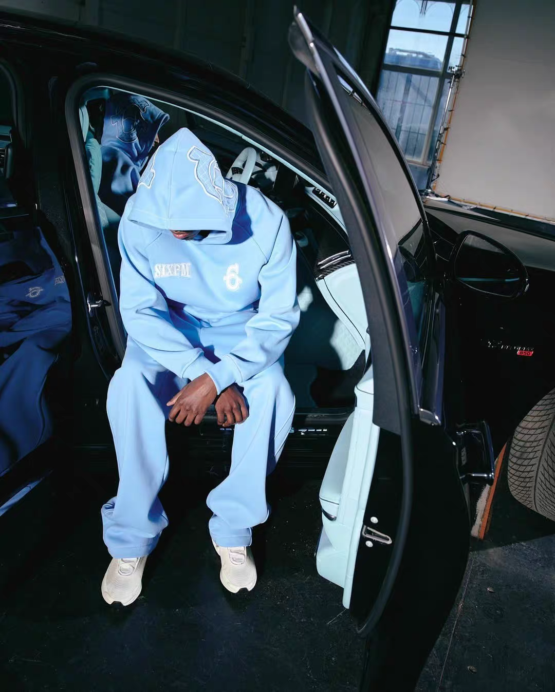Blue 6PM Tracksuit worn beside a car